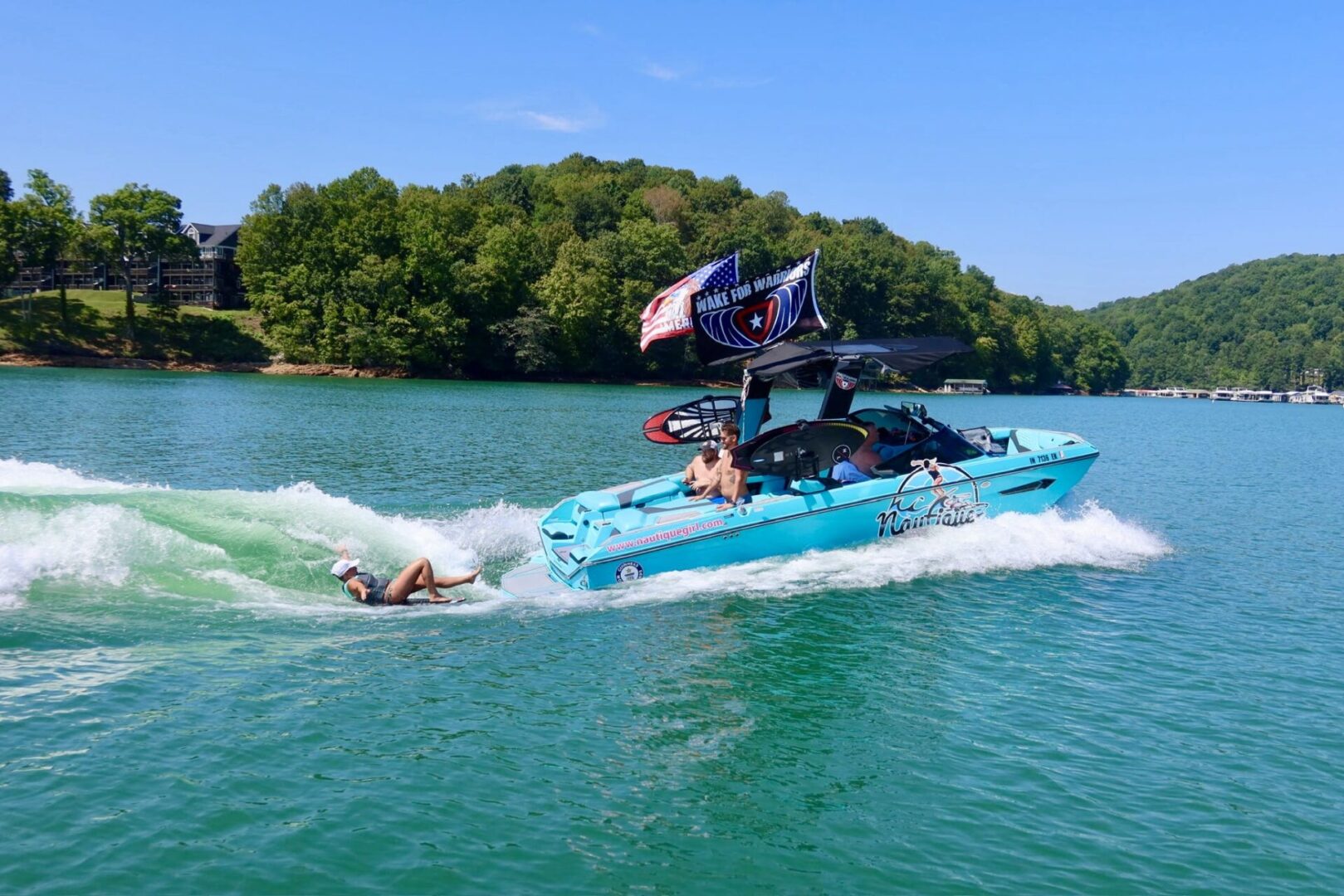 Boat towing person on a sunny lake.